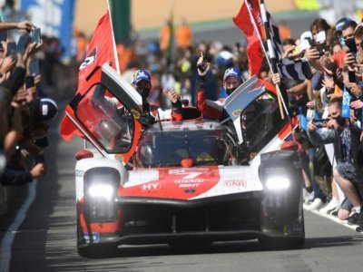 La Toyota N.7, pilotée par le Japonais Kamui Kobayashi, entouré de ses coéquipiers l'Argentin José Maria Lopez et le Britannique Mike Conway (d), après la victoire aux 24H du Mans, le 22 août 2021 - Jean-Francois MONIER [AFP]