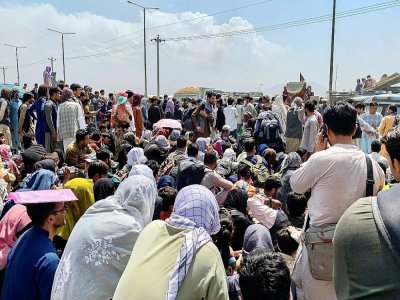 Des Afghans attendent déspérément une évacuation après l'arrivée au pouvoir des talibans, à l'aéroport de Kaboul le 20 août 2021 - Wakil KOHSAR [AFP]