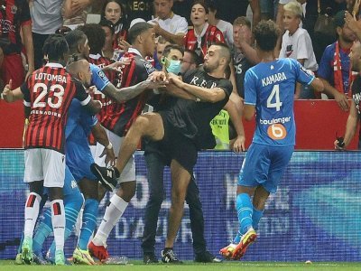 Des joueurs de Nice et de Marseille bloquent un supporter qui tente de donner un coup de pied au joueur marseillais Dimitri Payet (2e g) lors du match de L1 Nice-Marseille interrompu, le 22 août 2021 à Nice - Valery HACHE [AFP]