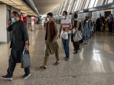 Des Afghans à leur arrivée à l'aéroport de Dulles, après leur évacuation, le 23 août 2021 en Virginie - ANDREW CABALLERO-REYNOLDS [AFP]