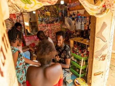 Debonheur Koli et des clientes dans son échoppe, à Bangui le 13 juillet 2021 - Barbara DEBOUT [AFP]