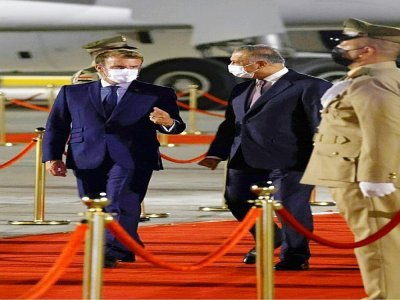 Le président français Emmanuel Macron (G) est accueilli à l'aéroport de Bagdad par le Premier ministre irakien Mustafa al-Kadhemi avant une conférence régionale - Ludovic MARIN [AFP]
