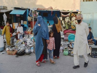 Une femme portant une burqa (c) devant un étal d'un marché de Kaboul, le 25 août 2021 - WAKIL KOHSAR [AFP/Archives]