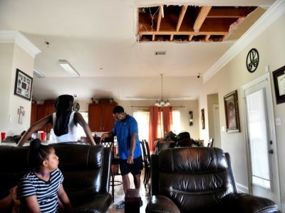 Des membres de la famille Arceneaux observent le plafond effondré de leur domicile, à Laplace, en Louisiane, le 30 août 2021 - Patrick T. FALLON [AFP]