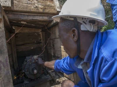 Electricien autodidacte, Colrerd Nkosi inspecte le 23 août 2021 la petite centrale hydro-électrique artisanale qu'il a construite pour éclairer son village de Yobe Nkosi, dans le Nord du Malawi - AMOS GUMULIRA [AFP]