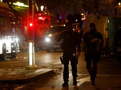 Des policiers marchent près du Bataclan dans la nuit du 13 au 14 novembre 2015 - FLORIAN DAVID [AFP/Archives]