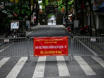 Des barrières métalliques au milieu d'une rue de Hanoï pour restreindre les déplacements des habitants, le 30 août 2021 au Vietnam - Manan VATSYAYANA [AFP]