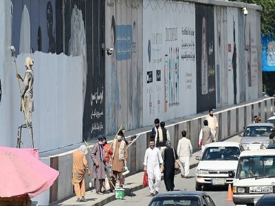 Des peintres recouvrent des inscriptions murales de peinture dans une rue de Kaboul, le 4 septembre 2021 - Aamir QURESHI [AFP]