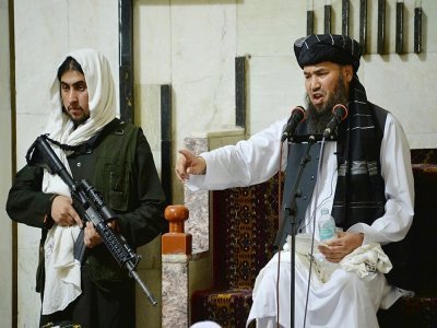 Un combattant taliban monte la garde près d'un mollah lors de la prière du vendredi le 3 septembre 2021 dans une mosquée de Kaboul - HOSHANG HASHIMI [AFP]