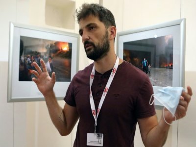 Le photographe grec de l'AFP Angelos Tzortzinis explique les histoires derrière ses photos exposées au festival international du photojournalisme à Perpignan, le 2 septembre 2021 - RAYMOND ROIG [AFP]