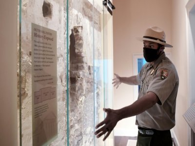 Le ranger Aaron LaRocca montre un mur d'origine de la bâtisse de la Maison Arlington, daté de 1802, le 24 août 2021 - Olivier DOULIERY [AFP]