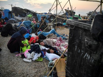 Des réfugiés et des migrants dorment sur la route menant à Mytilène, sur l'île grecque de Lesbos, le 12 septembre 2020, quelques jours après l'incendie qui a détruit le camp de Moria - LOUISA GOULIAMAKI [AFP/Archives]