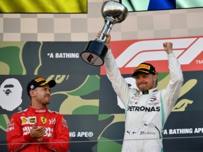 Valtteri Bottas soulève le trophée de la sa victoire dans le GP du Japon sous le regard de Sebastian Vettel, le 13 octobre 2019 à Suzuka - TOSHIFUMI KITAMURA [AFP/Archives]