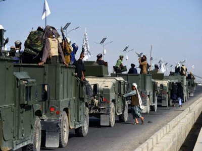 Des combattants talibans grimpent sur des véhicules Humvee pour parader après le retrait américain d'Afghanistan, à Kandahar le 1er septembre 2021 - JAVED TANVEER [AFP]