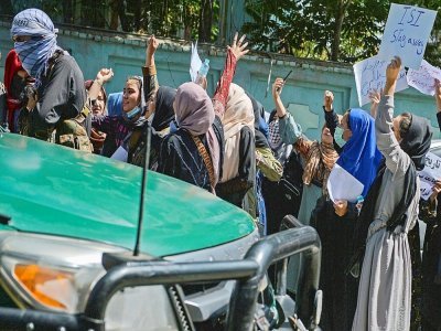 Des Afghanes manifestent près de l'ambassade du  Pakistan, sous l'oeil d'un combattant taliban, à Kaboul le 7 septembre 2021 - Hoshang Hashimi [AFP]