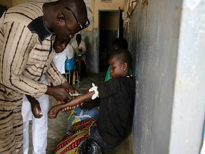 Une petite fille reçoit une injection pour soigner son paludisme dans un dispensaire de Ziniare, au Burkina Faso, le 20 août 2019 - Olympia DE MAISMONT [AFP/Archives]