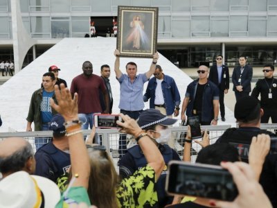 Le président brésilien Jair Bolsonaro brandit une représentation de Jésus-Christ devant des militants anti-avortement à Brasilia, le 18 avril 2020 - Sergio LIMA [AFP/Archives]