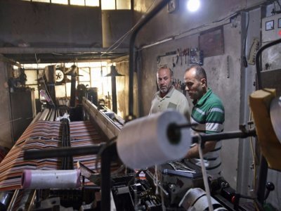 Des ouvriers dans un atelier de confection textile, le 30 août 2021 à Alep, en Syrie - - [AFP]