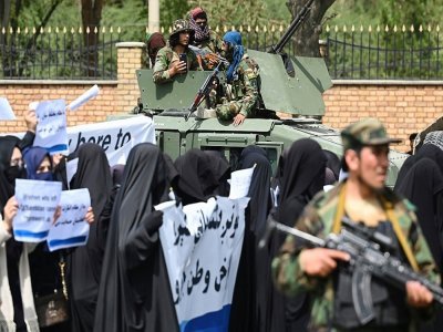Des combattants talibans encadrent une marche d'Afghanes en niqabs noirs lors d'un rassemblement devant l'Université Shaheed Rabbani, le 11 septembre 2021 à Kaboul - Aamir QURESHI [AFP]