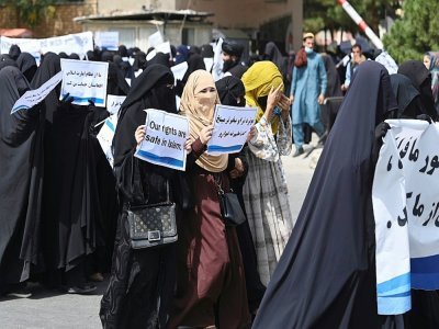 Des Afghanes en niqabs noirs défilent avec des pancartes pro-talibans devant l'université Shaheed Rabbani, le 11 septembre 2021 à Kaboul - Aamir QURESHI [AFP]