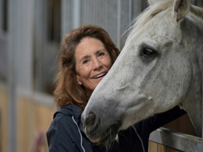 Reha Hutin, présidente de la Fondation 30 Millions d'amis, caresse un cheval au refuge de la Fondation, le 9 septembre 2021 à Bannegon, dans le Cher - GUILLAUME SOUVANT [AFP]