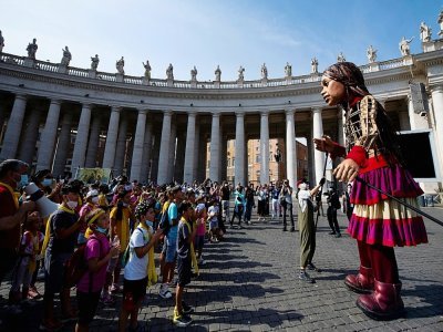 Des personnes se rassemblent devant "Little Amal" (la petite Amal), une poupée géante représentant une jeune refugiée syrienne sur la place Saint-Pierre au Vatican, le 1O septembre 2021 - Tiziana FABI [AFP]