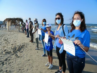 Des Tunisiens forment une impressionnante chaîne humaine sur cinq plages de la banlieue sud de Tunis pour protester contre la pollution marine le 12 septembre 2021 - ANIS MILI [AFP]