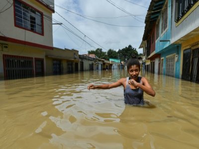 Une fille marche à travers une rue inondée à Cali, en Colombie, le 13 mai 2017 - LUIS ROBAYO [AFP/Archives]