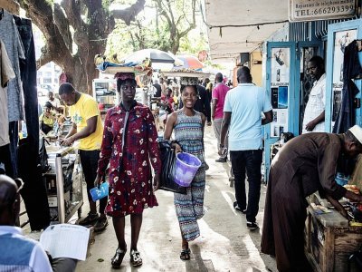 Des marchandes de fruits et d'arachides dans une rue de Conakry le 11 septembre 2021 - JOHN WESSELS [AFP]