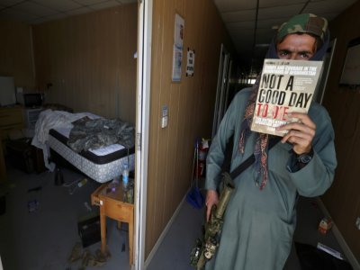 Un combattant taliban brandit le livre "Not a good day to die" ("Pas un bon jour pour mourir"), dans un ex-camp de l'armée américaine dans l'aéroport de Kaboul, le 14 septembre 2021 - Karim SAHIB [AFP]