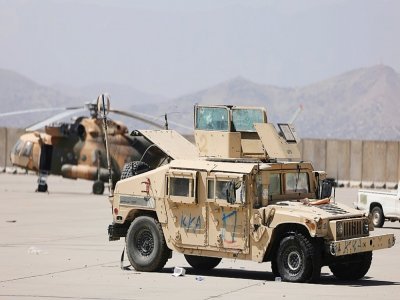 Un hélicoptère des forces afghanes et un véhicule militaire stationnés sur l'aéroport de Kaboul le 14 septembre 2021 - Karim SAHIB [AFP]