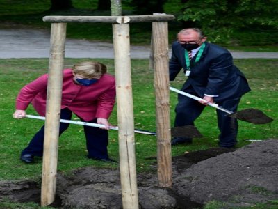 La chancelière Angela Merkel et le maire de Templin, Detlef Tabbert, creusent le sol pour y planter un tilleul, le 10 septembre 2021, à l'occasion du 750ème anniversaire de la ville où a grandi Mme Merkel - John MACDOUGALL [AFP/Archives]