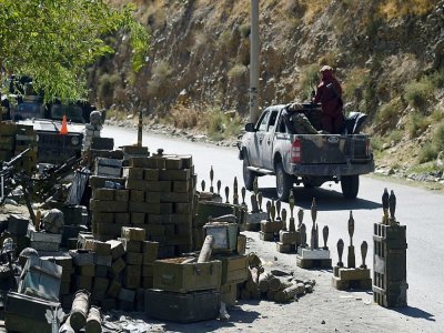 Des combattants talibans passent devant des munitions sur une route du district de Bazark dans le Panchir dont ils ont pris le contrôle, le 15 septembre 2021 - WAKIL KOHSAR [AFP]