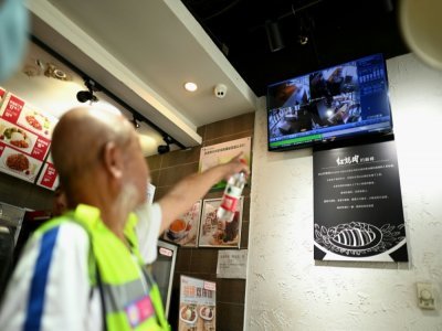 Des volontaires à la recherche de Chen Shaohua, un malade d'Alzheimer ayant disparu, regardent les images de vidéosurveillance du centre commercial où le sexagénaire a été vu pour la dernière fois, le 19 juillet 2021 à Pékin - NOEL CELIS [AFP]
