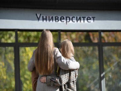 Deux étudiantes devant le panneau de l'université de Perm le 21 septembre 2021 - NATALIA KOLESNIKOVA [AFP]