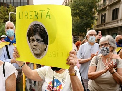 Un manifestant brandit un portrait de Carles Puigdemont lors d'une manifestation devant le consulat italien à Barcelone, le 24 septembre 2021 - LLUIS GENE [AFP]