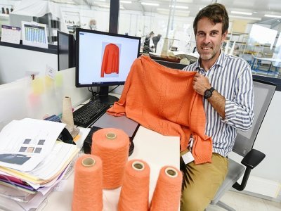 Basile Ricquier, un des trois fondateurs de la PME 3D Tex, montre un pull réalisé sur un métier à tisser 3D, le 17 septembre 2021 à Saint-Malo - JEAN-FRANCOIS MONIER [AFP]