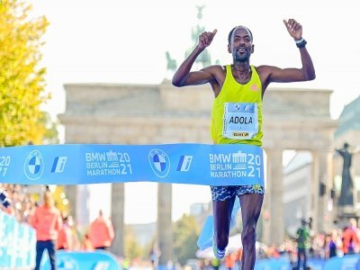 L'Ethiopien Guye Adola franchit en vainqueur la ligne d'arrivée du marathon de Berlin, le 26 septembre 2021 - Tobias SCHWARZ [AFP]