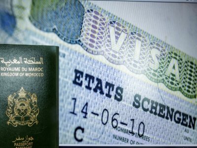 Un passeport marocain et la page d'accueil de demande de visa pour l'espace Schengen, à Rabat le 28 septembre 2021 - FADEL SENNA [AFP]