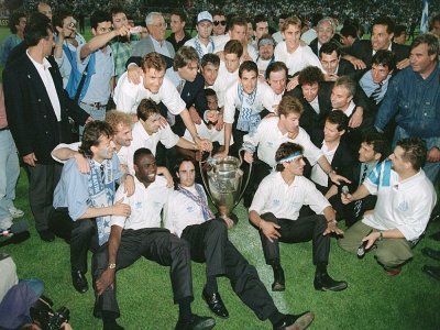 Le 27 mai 1993 au Stade Vélodrome, à Marseille, Bernard Tapie pose avec les joueurs de l'Olympique Marseille (OM) et la Coupe d'Europe des clubs champions que le club vient de remporter face au Milan AC - BORIS HORVAT [AFP/Archives]