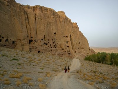 Des membres des talibans passent le 2 octobre 2021 près du site où les bouddhas géants ont été détruits par les islamistes en mars 2001 à Bamiyan - BULENT KILIC [AFP]