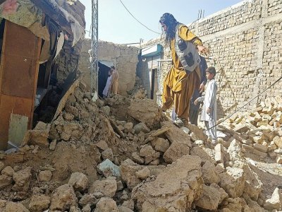 Des habitants sur les débris de leurs maisons qui se sont effondrées lors d'un séisme de magnitude 5,9 dans le secteur d'Harnai au Pakistan, le 7 octobre 2021 - Banaras KHAN [AFP]