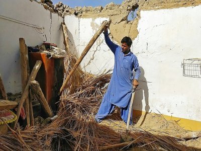 Un habitant inspecte sa maison qui s'est effondrée lors d'un séisme de magnitude 5,9 dans le secteur d'Harnai au Pakistan, le 7 octobre 2021 - Banaras KHAN [AFP]