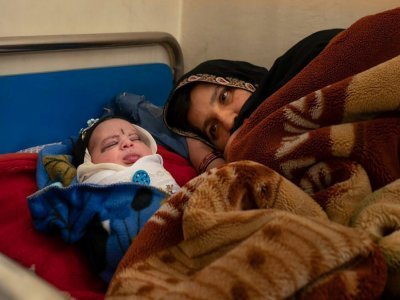 Une mère se repose près de son bébé à la clinique de Tangi Saidan,  le 6 octobre 2021 dans le centre de l'Afghanistan - Elise BLANCHARD [AFP]