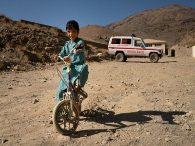 Un enfant à vélo devant la clinique de Tangi Saidan,  le 6 octobre 2021 dans le centre de l'Afghanistan - Elise BLANCHARD [AFP]