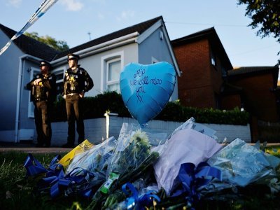 Des hommages sont placés près du lieu de l'aggression à l'arme blanche, tandis que des officiers de police montent la garde près de l'église méthodiste de Belfairs à Leigh-on-Sea, dans le sud-est de l'Angleterre, le 15 octobre 2021 - Tolga Akmen [AFP]