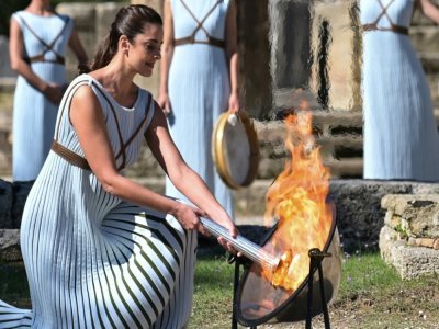 La flamme olympique est allumée par l'actrice grecque Xanthi Georgiou, durant la cérémonie sur le site historique d'Olympe, le 18 octobre 2021 - ARIS MESSINIS [AFP]
