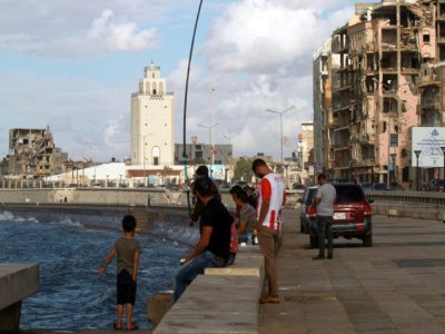 Des Libyens face à la mer, dans la ville de Benghazi, dans le nord-est de la Libye, le 15 octobre 2021 - Abdullah DOMA [AFP]