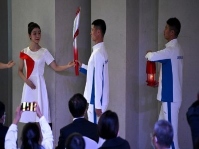Torche et flamme olympique arrivant à la cérémonie d'arrivée de la flamme à la Tour olympique de Pékin le 20 octobre 2021 - Noel Celis [AFP]