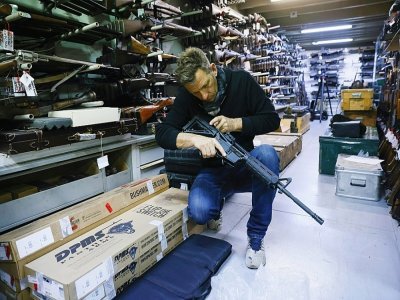 L'armurier Christophe Maratier manipule une arme dans son armurerie de La Courneuve, près de Paris, le 22 octobre 2021 - THOMAS SAMSON [AFP]